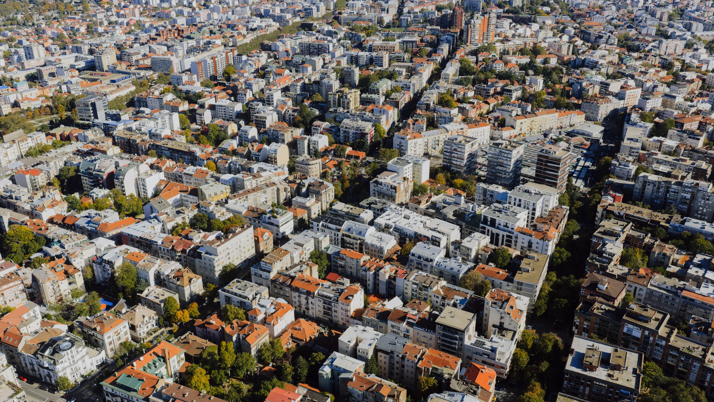 An aerial view of dense city blocks with red-tiled roofs