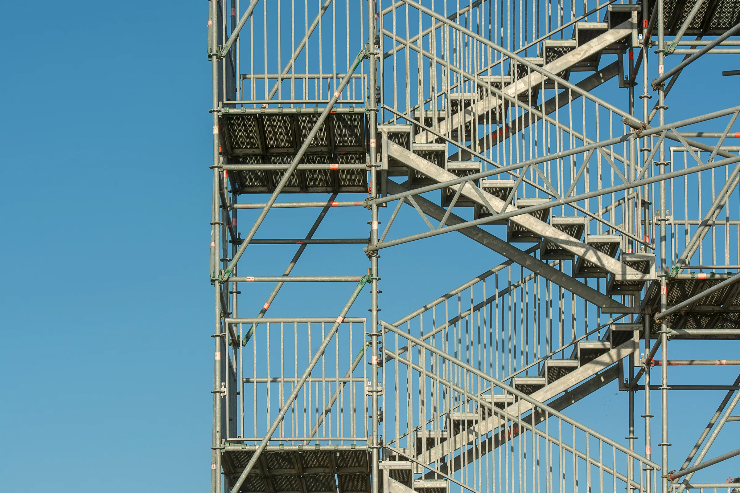 Steel scaffolding rising against a clear blue sky